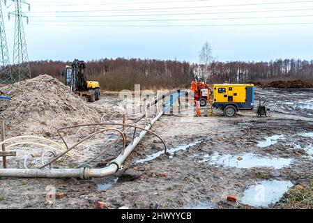 Installation Wellpoint pour se débarrasser des eaux souterraines élevées, des tuyaux en métal et en plastique visibles et d'une grande pompe à eau. Banque D'Images