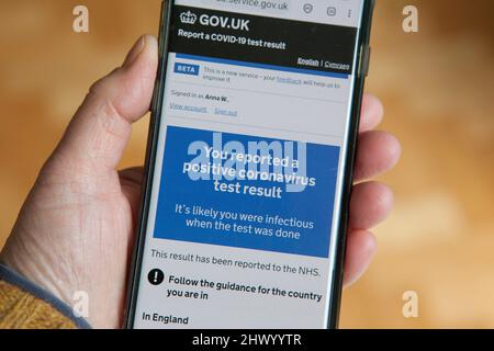 Londres, Royaume-Uni, 8 mars 2022 : un smartphone affiche des messages du NHS en réponse à un test de débit latéral positif. Le gouvernement n'exige plus que les personnes avec Covid-19 s'auto-isolent, mais les apps conseillent toujours l'auto-isolement pendant 11 jours à partir du jour du test positif initial. Au cours de la semaine dernière, les nouveaux tests de covid signalés ont augmenté de 39% par rapport aux chiffres de la semaine précédente, un résultat probable de la politique anglaise de suppression de tous les contrôles de covid. Anna Watson/Alamy Banque D'Images