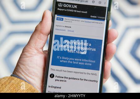 Londres, Royaume-Uni, 8 mars 2022 : un smartphone affiche des messages du NHS en réponse à un test de débit latéral positif. Le gouvernement n'exige plus que les personnes avec Covid-19 s'auto-isolent, mais les apps conseillent toujours l'auto-isolement pendant 11 jours à partir du jour du test positif initial. Au cours de la semaine dernière, les nouveaux tests de covid signalés ont augmenté de 39% par rapport aux chiffres de la semaine précédente, un résultat probable de la politique anglaise de suppression de tous les contrôles de covid. Anna Watson/Alamy Banque D'Images