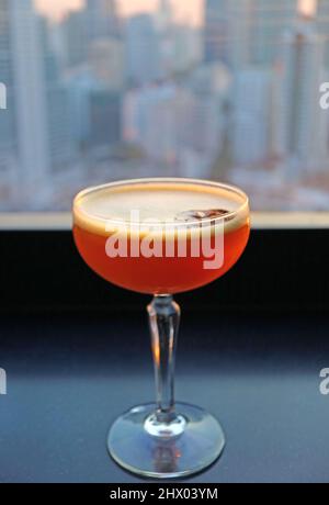 Verre de cocktail sur la terrasse sur le toit avec vue aérienne sur la ville en arrière-plan Banque D'Images