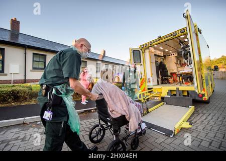 Les ambulanciers paramédicaux déplacent un patient dans leur ambulance après avoir examiné le patient à leur domicile près de Pontypool, S. Wales UK Banque D'Images