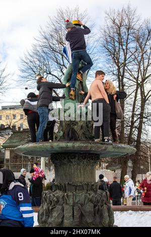 Des jeunes grimpent sur la sculpture en bronze Havis Amanda pour célébrer la médaille d'or du hockey olympique à Helsinki, en Finlande Banque D'Images