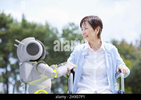 Femme âgée en fauteuil roulant et Robot de soins Banque D'Images