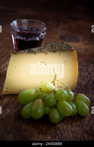 fromage de montagne avec raisins sur bois Banque D'Images