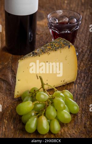 fromage de montagne avec raisins sur bois Banque D'Images