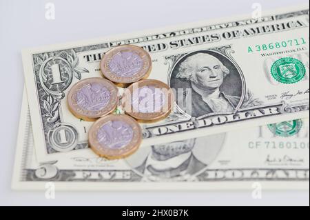 Quatre pièces de livre sterling sur des billets en dollars américains Banque D'Images