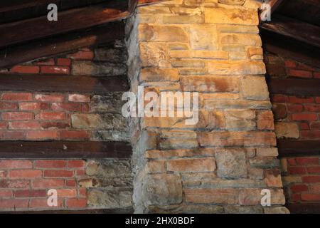 Cheminée en pierre contre la brique et le mur de bois Banque D'Images