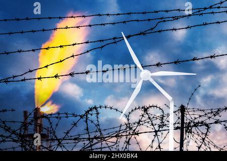 Usine de gaz industriel derrière une clôture barbelée avec éolienne cassée. Crise énergétique, Russie, conflit en Ukraine, cdp 26, guerre, énergies renouvelables, combustibles fossiles Banque D'Images