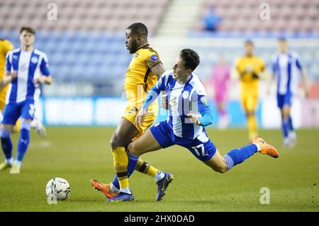 Jamie McGrath de Wigan Athletic (à droite) et David Ajiboye de Sutton United se battent pour le ballon lors du match semi-final Papa John's Trophy au DW Stadium, à Wigan. Date de la photo: Mardi 8 mars 2022. Banque D'Images