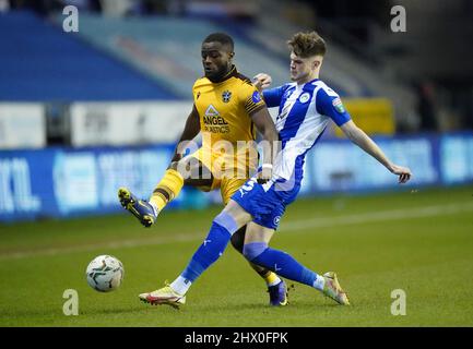 Tom Pearce de Wigan Athletic (à droite) et David Ajiboye de Sutton United se battent pour le ballon lors du match semi-final Papa John's Trophy au DW Stadium, Wigan. Date de la photo: Mardi 8 mars 2022. Banque D'Images