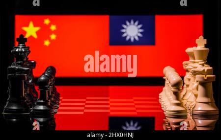 Image conceptuelle de la guerre entre la Chine et Taïwan utilisant des pièces d'échecs et des drapeaux nationaux sur un fond réfléchissant Banque D'Images