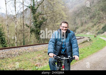 Kordel, Rhénanie-Palatinat - Allemagne - 04 09 2019 Homme sur un vélo de randonnée le long d'une voie ferrée dans les collines Banque D'Images