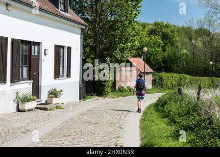 Jette, Bruxelles - Belgique - 04 21 2019 - Femme marchant sur une route piétonne pavée à travers la scène rurale du parc de la ville de Boudewijn Banque D'Images