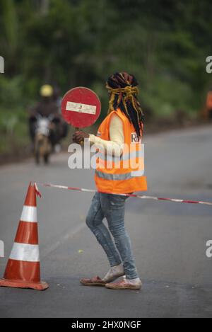 Jeune femme dans une veste orange tenant un panneau de non-entrée Banque D'Images