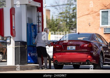 Arlington, États-Unis. 8th mars 2022. Un homme alimente une voiture à une station-service d'Arlington, en Virginie, aux États-Unis, le 8 mars 2022. La moyenne nationale américaine pour un gallon d'essence ordinaire a atteint mardi un nouveau record de 4,173 dollars américains, selon les données de l'American automobile Association (AAA). Credit: Liu Jie/Xinhua/Alay Live News Banque D'Images