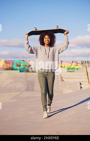 Pourquoi marcher quand vous pouvez skate. Photo d'une jeune femme sur le skateboard dans la ville. Banque D'Images