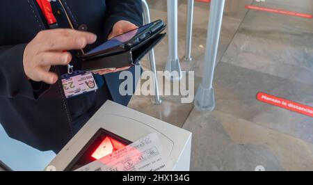 Un personnel d'Iberia vérifiant une carte d'embarquement, scannant électroniquement pendant l'enregistrement avant d'embarquer à la porte de l'aéroport de Madrid-Barajas, Espagne Banque D'Images