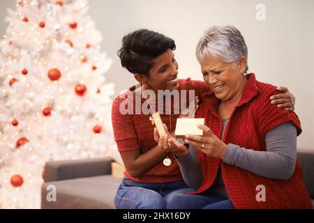 Découvrir les joies du don et de la réception. Une femme âgée recevant un cadeau de sa fille à Noël. Banque D'Images