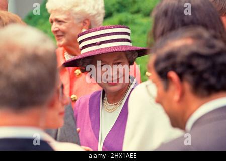 La reine Elizabeth II de Grande-Bretagne, au centre, s'adresse à des invités dans le jardin des roses de la Maison Blanche à Washington, DC après avoir remis le prix Churchill au président des États-Unis George H.W. Bush lors d'une visite d'État le 14 mai 1991. En arrière-plan en haut à gauche se trouve la première dame Barbara Bush. Crédit: Arnie Sachs/CNP Banque D'Images