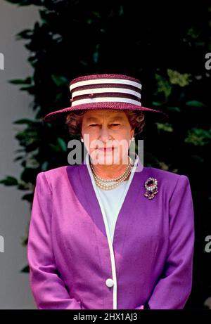 La reine Elizabeth II de Grande-Bretagne, au centre, s'adresse à des invités dans le jardin des roses de la Maison Blanche à Washington, DC après avoir remis le prix Churchill au président des États-Unis George H.W. Bush lors d'une visite d'État le 14 mai 1991. En arrière-plan en haut à gauche se trouve la première dame Barbara Bush. Crédit: Arnie Sachs/CNP Banque D'Images