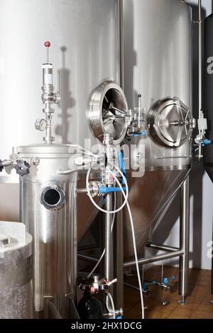 Équipement pour la production de bière artisanale, récipients de fermentation dans la chambre climatique, manomètre à tubes et réservoirs en acier inoxydable. Banque D'Images