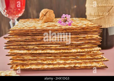 Concept de célébration de Pesach - Fête de la Pâque juive. Pile de matzah, bouteille de vin avec verre et noix. Gros plan Banque D'Images