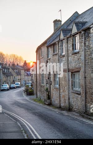 Witney Street au lever du soleil en mars. Burford, Cotswolds, Oxfordshire, Angleterre Banque D'Images