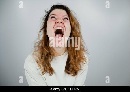 Portrait en gros plan d'une femme aliénée en blouson sur fond blanc. Banque D'Images