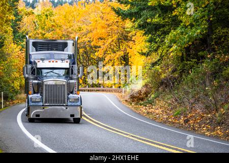 Classique américain grand rig semi-camion industriel transportant des marchandises commerciales dans réfrigérateur semi-remorque fonctionnant sur la route de montagne d'automne avec vous Banque D'Images