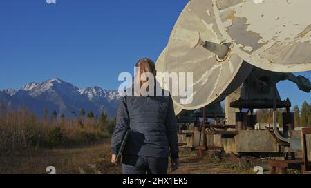 Une femme étudiante-opérateur de l'institut de physique terrestre solaire surveille les équipements de communication dans un ordinateur portable. Radiotélescope solaire à faisceau unique. Radiotélescope solaire Sun. L'observatoire 'Quasar' à Badary, Russie. Plats satellites dans les montagnes. Banque D'Images