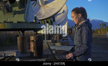 Femme étudiante opérateur de l'institut de physique terrestre solaire drôle s'amuser, se reposer après le travail à l'ordinateur portable. Radiotélescope solaire à faisceau unique. Radiotélescope solaire Sun. L'observatoire 'Quasar' à Badary, Russie. Plats satellites dans les montagnes. Banque D'Images