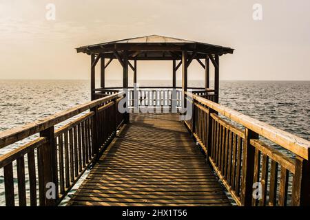 Une jetée couverte en bois sur le front de mer de la ville de Garda sur la rive est du lac de Garde, province de Vérone, Vénétie, nord-est de l'Italie Banque D'Images