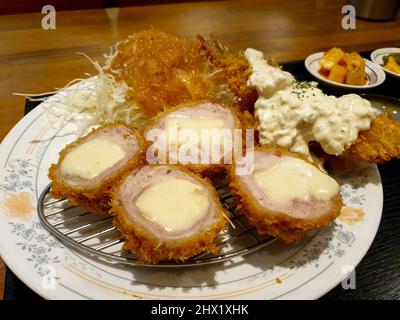 Le fromage Katsu, un rôti de porc pané japonais, frits et fourrés de fromage. Servi avec de la salade de chou. Banque D'Images