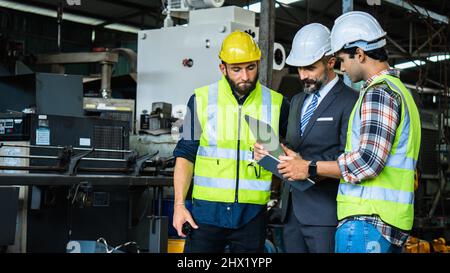 Ingénieur industriel et homme d'affaires en casque de sécurité travaillant en usine, la planification, la discussion et la formation des travailleurs avec la tablette dans le lieu de travail métallique , te Banque D'Images