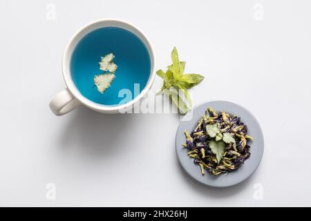 Tasse de thé bleu et fleurs séchées de pois papillons sur fond clair Banque D'Images