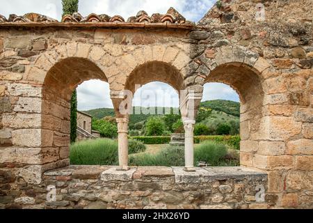 Vue à travers les fenêtres voûtées de la Renaissance bien conservées du jardin de l'abbaye de Sant Antimo. Toscane, Italie Banque D'Images