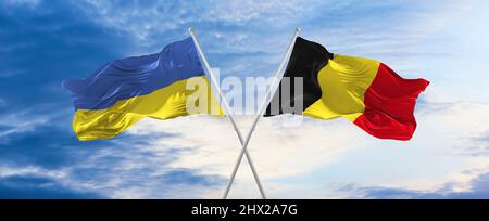 Deux drapeaux croisés la Belgique et l'Ukraine agitant dans le vent à ciel nuageux. Concept de relation, de dialogue, de voyage entre deux pays. 3d illustration Banque D'Images