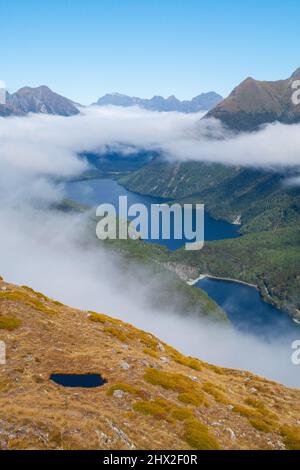 Le brouillard de la vallée se dissolvant au-dessus des lacs de montagne, vue de Key Summit Ridge, du lac Gunn Fergus et de la chaîne Livingstone, Fiordland, Île du Sud de la Nouvelle-Zélande Banque D'Images