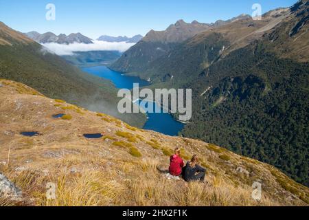 Couple de randonnée en admirant la vue panoramique sur les lacs Fergus, le lac Gunn et la chaîne de montagnes de Livingstone, sentier inconnu de Key Summit, Fiordland, Nouvelle-Zélande Banque D'Images