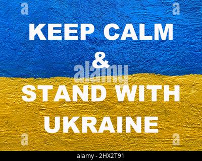 Message Gardez calme et tenez-vous debout avec l'Ukraine sur le drapeau ukrainien peint sur le mur Banque D'Images