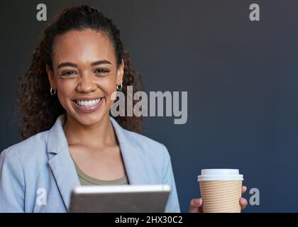 Une jeune femme se tient avec son café et sa tablette numérique préparés pour la journée Banque D'Images