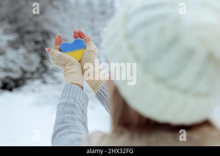 Pas de guerre. Février le début de la guerre en Ukraine la jeune fille tient un coeur d'une couleur bleue pathétique dans ses mains. La paix en Ukraine Banque D'Images