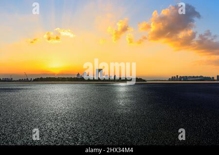 Autoroute en asphalte et horizon de la ville avec des bâtiments modernes à Suzhou au coucher du soleil, en Chine. Banque D'Images