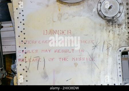 Danger, une interférence avec ces câbles peut entraîner le dégagement du missile. Message d'avertissement à l'intérieur de la baie de bombe de l'ancien bombardier nucléaire RAF Avro Vulcan Banque D'Images