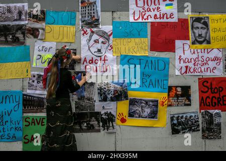 Beyrouth, Liban. 09th mars 2022. Une femme ukrainienne vivant au Liban fixe une affiche factice du président russe Vladimir Poutine sur le mur de l'ambassade de Russie à Beyrouth lors d'une manifestation contre l'invasion russe de l'Ukraine, qui entre dans sa troisième semaine. Credit: Marwan Naamani/dpa/Alamy Live News Banque D'Images