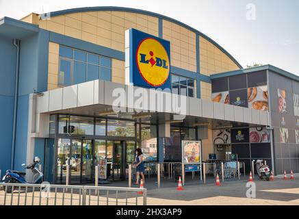 Corfou, Grèce - 03 août 2021: Les gens visitent le supermarché Lidl avec parking. Lidl est une chaîne allemande de supermarchés à prix réduit qui opère plus de 7200 s. Banque D'Images