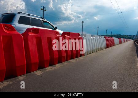 Barrières routières en plastique remplies d'eau rouge et blanche. Banque D'Images