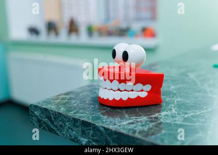 Miniatures de mâchoires dentaires artificielles avec yeux. Un modèle en plastique de dents est posé sur une table dans le bureau d'un dentiste. Banque D'Images