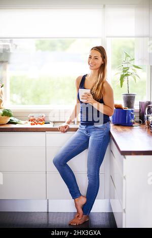 J'aime les grandes tasses et je ne peux pas mentir. Photo d'une jeune femme ayant un café dans sa cuisine. Banque D'Images