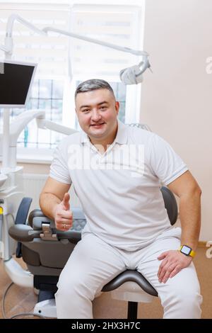 Le concept de médecine, de profession, de dentisterie et de médecine - un dentiste d'âge moyen souriant sur le fond d'un bureau médical. Le dentiste est en h. Banque D'Images